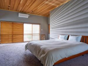 una camera da letto con un letto grande e una grande finestra di ＭＯＲＩＴＯ Ｆｕｎｎｙ ｈｏｕｓｅ - Vacation STAY 72253v a Hayama