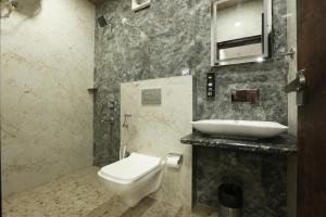 a bathroom with a toilet and a sink at Airport Hotel Bright Buzz in New Delhi