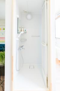 a shower in a white bathroom with a sink at GUEST HOUSE BLUE DOORS - Vacation STAY 73130v in Yamagata