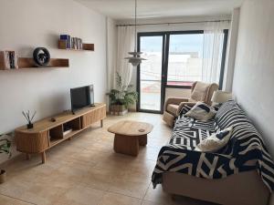 un salon avec un canapé et une télévision dans l'établissement Casa Dana El Cotillo with private terrace, à El Cotillo