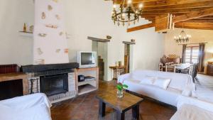 a living room with a white couch and a fireplace at El Zorro Almáchar by Ruralidays in Almáchar