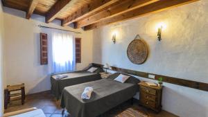 a bedroom with two beds in a room with a window at El Zorro Almáchar by Ruralidays in Almáchar +25 photos