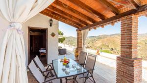 a table and chairs on a patio with a view at Juan Manuel - Los Mangos El Borge by Ruralidays in Borge