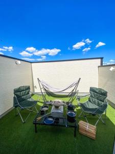 a patio with a hammock and two chairs and a table at Shinchiku design house - Vacation STAY 15468 in Ranzan +17 photos