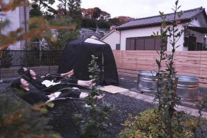 two people laying on a bench in a garden at Nami to Tuki - Vacation STAY 15960 in Oarai