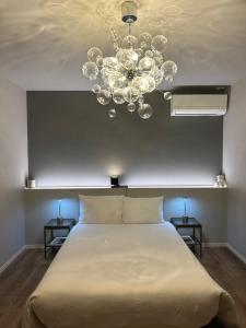 a bedroom with a large bed and a chandelier at Shinchiku design house - Vacation STAY 15468 in Ranzan