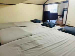 two beds in a hotel room with blue pillows on them at Real Corp 202 - Vacation STAY 78099v in Chiba