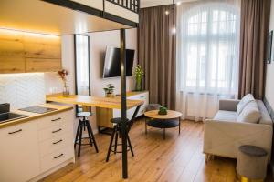 a kitchen and living room with a table and a couch at Piernikowe by Rentoom in Toruń