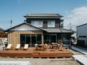 a house with a wooden deck with chairs and a table at Sea saw - Vacation STAY 91738v in Isumi