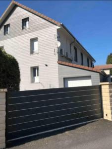 a house with a black garage fence at Appartement à La Bresse, proche des lacs, pistes de ski et randonnées in La Bresse