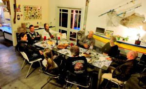 un grupo de personas sentadas alrededor de una mesa comiendo en Pousada Villa da Nascente, en Florianópolis