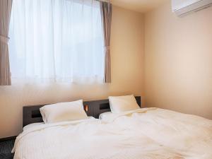 two beds in a bedroom with a window at Asama no Iori - Vacation STAY 01001v in Fujiyoshida