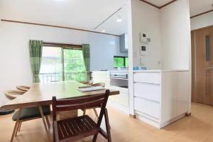 a kitchen with a wooden table and a dining room at Itsukaichi First Villa Hiroshima - Vacation STAY 15653 in Hiroshima
