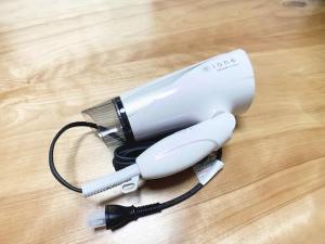 a white electric hair dryer on a wooden floor at Itsukaichi First Villa Hiroshima - Vacation STAY 15653 in Hiroshima