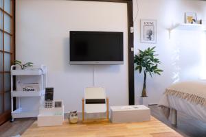 a bedroom with a flat screen tv on a wall at green park heights - Vacation STAY 15686 in Musashino