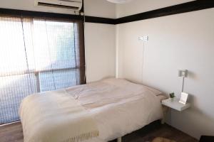 a bedroom with a white bed and a window at green park heights - Vacation STAY 15686 in Musashino +2 photos