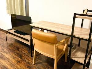 ein Holztisch mit einem Stuhl neben einem Schreibtisch in der Unterkunft Hakodatekan - Vacation STAY 07879v in Hakodate