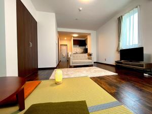 ein Wohnzimmer mit Sofa und Fernseher in der Unterkunft Hakodatekan - Vacation STAY 07879v in Hakodate
