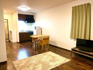 a living room with a table and a kitchen at Hakodatekan - Vacation STAY 07877v in Hakodate