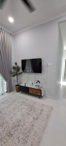 Bukit PayongにあるRaudhah Homestay Tasek Kuala Terengganuの白いリビングルーム(テレビ、テーブル付)