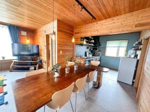 a dining room with a large wooden table and chairs at Base Shiraoi - Vacation STAY 89919v in Shikyū