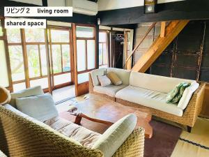 a living room with two couches and a table at TAKIO 2 guesthouse in Higashi-osaka +22 photos