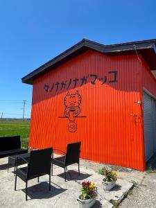 a red building with a table and chairs in front of it at Tanonagano Yadokko - Vacation STAY 62252v in Goshogawara