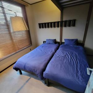 two beds in a bedroom with purple sheets and a window at Minato no minato 1391-8 - Vacation STAY 92224v in Minamiawaji