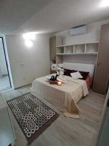 ein Schlafzimmer mit einem Bett und einem Tisch mit Blumen darauf in der Unterkunft Villa Rosi in Costa Paradiso