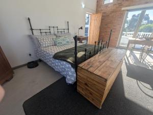 a bedroom with a bed and a wooden table at Walmer Haven - Cosy Retreat in Gqeberha
