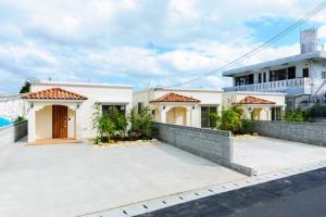 a large white house with a large driveway at Bears Stay Kumejima Villa - Vacation STAY 01040v in Kumejima