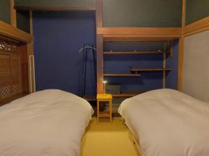 ein Schlafzimmer mit zwei Betten und einer blauen Wand in der Unterkunft Oikura-juku Seizan - Vacation STAY 23376v in Minamiboso + 3 Fotos