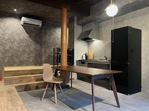 eine Küche mit einem Holztisch und einem schwarzen Kühlschrank in der Unterkunft Oikura-juku Seizan - Vacation STAY 23376v in Minamiboso