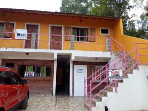 a house with a red car parked in front of it at Monoambiente San Bernardo in San Bernardo