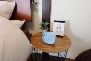 a blue clock on a table next to a bed at green park heights - Vacation STAY 15684 in Musashino +3 photos