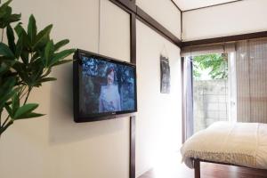 a television hanging on a wall in a bedroom at green park heights - Vacation STAY 15684 in Musashino