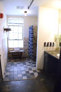 a bathroom with a shower with a bench and a window at Firehouse Hostel in Austin
