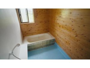 a bathroom with a bath tub in a wooden wall at Oasis Minamiboso - Vacation STAY 04676v in Minamiboso