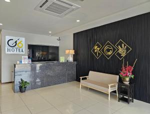 a lobby of a hotel with a chair and a counter at G Six Hotel in Sitiawan