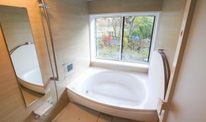 uma casa de banho com uma banheira grande e uma janela em Villa Shizen Hakuba - Vacation STAY 21391v em Hakuba mais 20 fotografias