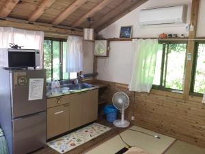 a small kitchen with a refrigerator and a sink at Nakano-san Chi Campsite & RV Park Hotaru no Sato- Camp - Vacation STAY 42210v in Higashi-shibuta