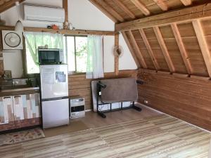 a kitchen with a refrigerator and a chair in a room at Nakano-san Chi Campsite & RV Park Hotaru no Sato- Camp - Vacation STAY 42210v in Higashi-shibuta