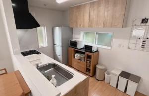 a small kitchen with a sink and a refrigerator at Villa & BBQ grounds Palm Village - Vacation STAY 42254v in Otohama