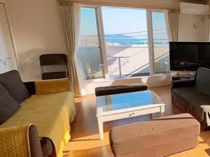 a living room with a couch and a tv at Villa & BBQ grounds Palm Village - Vacation STAY 42254v in Otohama