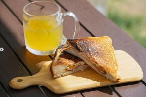 a sandwich on a cutting board next to a glass of orange juice at 99glam - Vacation STAY 42273v in Hirasawa