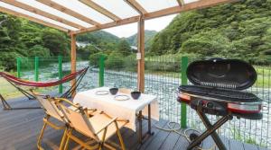 a porch with a grill and a table and chairs at SPRINGS VILLAGE Ashigara-Tanzawa Hot Spring Resort & Glamping - Vacation STAY 42301v in Oyama