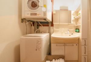 una piccola cucina con lavatrice e lavandino di Atami 2goukan Diamond Yu - Vacation STAY 13042v ad Atami