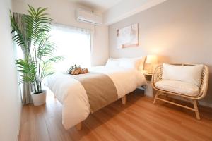 - une chambre avec un lit, une chaise et une plante dans l'établissement Shippo Mansion Room 402 - Vacation STAY 13861v, à Kichijōji