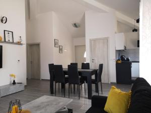 a dining room and living room with a table and chairs at House Kona in Zupci
