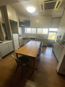a large kitchen with a wooden table and chairs at art village - Vacation STAY 20642v in Awa